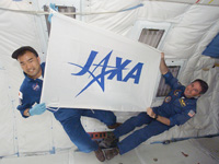 KC-135内でJAXAの旗を掲げる野口宇宙飛行士